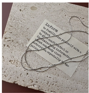 Dettaglio collana a catena in argento 925 su superficie in pietra beige minimalista