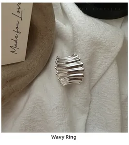 Vue macro d'une bague en argent sterling S925 avec texture ondulée et design épuré