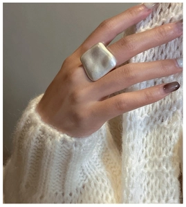 Close-up of matte S925 sterling silver square ring with wave texture on model's hand