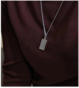 Gros plan détaillé d'un pendentif boulier en argent sterling S925 sur une fine chaîne