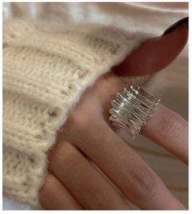 Détail d'une bague en argent sterling S925 texturée portée avec un pull en maille douce