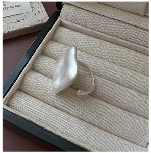 Macro detail of minimalist matte silver ring with irregular fluid geometric design