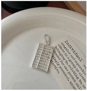 Vue macro d'un pendentif boulier en argent sterling S925 avec perles polies et poinçon