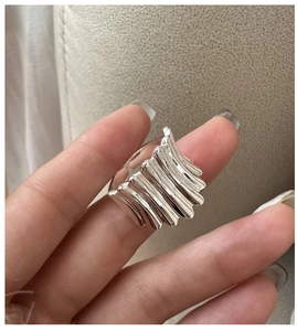 Détail macro de la bague argentée avec texture ondulée et finition plissée irrégulière
