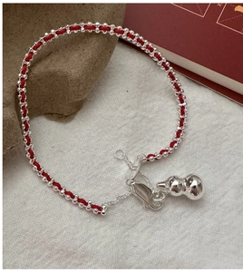 Detailed view of the S925 silver gourd charm on a red braided rope bracelet for women