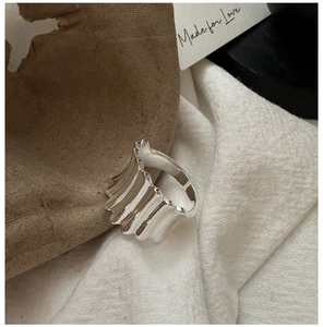 Détail d'une bague en argent S925 texturée à vagues sur un support en pierre naturelle