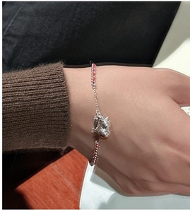 Macro shot of S925 sterling silver gourd pendant on a red braided string bracelet