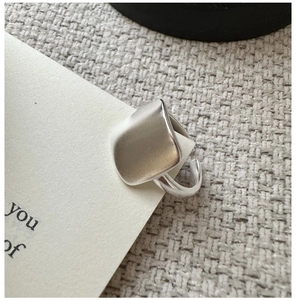 Gros plan d'une bague carrée mate en argent sterling S925 sur support cartonné