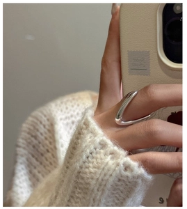 Gros plan d'une bague en V minimaliste en argent sterling S925 portée à la main avec douceur