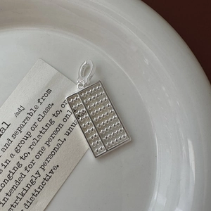 Pendentif boulier en argent sterling S925 avec perles mobiles sur assiette blanche