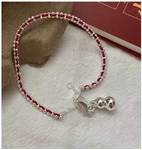 Detailed shot of S925 silver gourd charm on red braided rope with lobster clasp closure
