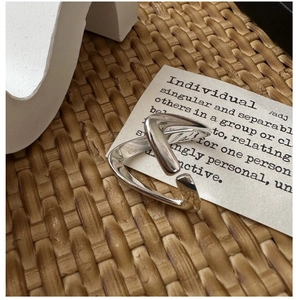 Gros plan d'une bague en V minimaliste en argent S925 avec finition polie brillante