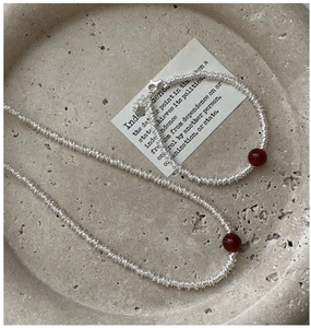 Detail of S925 silver wire wrapped necklace and bracelet set with red agate bead centerpiece