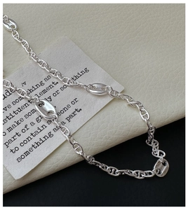 Vue détaillée du collier à maillons en argent avec pendentifs en forme de groin de porc