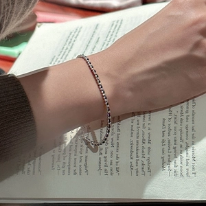 Minimalist S925 sterling silver beaded bracelet with adjustable chain on a book