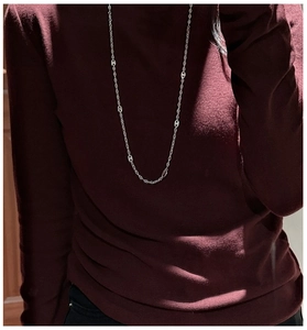 Détail du collier argent S925 avec maillons ovales sur un fond de pull en tricot rouge