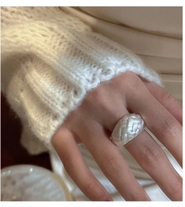 Close-up of wide S925 sterling silver ring with vintage woven texture on model hand