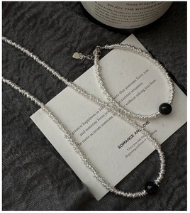 Vue détaillée de la chaîne argentée à perles d'onyx noir et pendentif cœur élégant