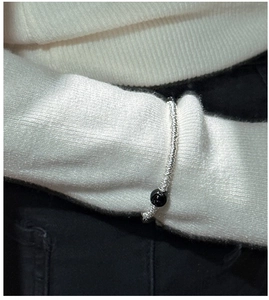 Détail d'un bracelet en argent S925 à perles avec une pierre d'onyx noire au poignet