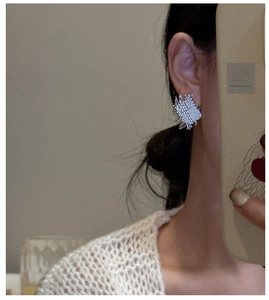 Close-up of S925 sterling silver square stud earring featuring woven metal texture