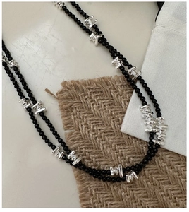 Détail du collier en argent S925 et onyx noir sur un fond de lin texturé de haute qualité