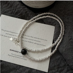 Détail du collier en argent torsadé avec perle d'agate noire et pendentif cœur