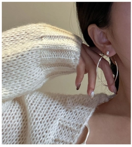 Gros plan de créoles minimalistes en argent avec un petit diamant sur un mannequin