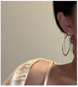 Gros plan de créoles minimalistes en argent sterling 925 portées par un mannequin chic