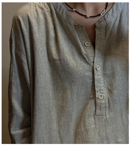 Gros plan d'une chemise rayée en coton et lin avec un collier de perles noires