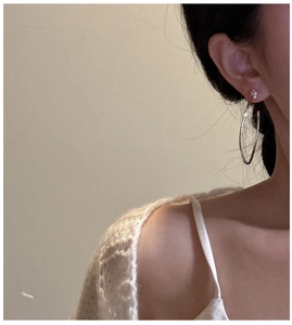 Gros plan de grandes créoles minimalistes en argent 925 sur un mannequin pour un style chic