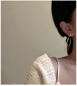 Gros plan de boucles d'oreilles créoles en argent 925 avec clous étoiles sur le modèle
