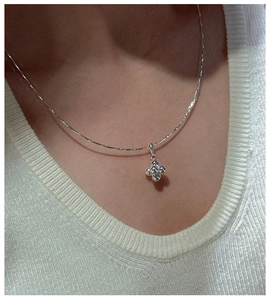 Macro view of S925 sterling silver ball pendant necklace worn on a woman's neck
