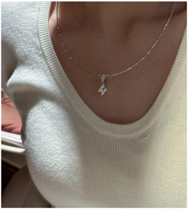 Detail of S925 sterling silver ball necklace with minimalist sparkling clover pendant