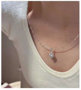 Macro view of S925 sterling silver four-petal flower pendant necklace with zircon stone