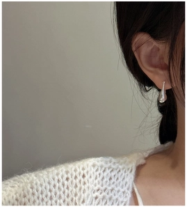 Silver teardrop earrings worn by a model with a minimalist and elegant jewelry style