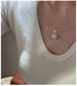 Macro detail of S925 sterling silver flower pendant necklace with sparkling zircons