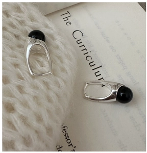Detail of S925 sterling silver horseshoe earrings with polished black agate beads