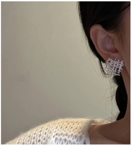 Gros plan de boucles d'oreilles minimalistes en argent S925 tressé portées par un mannequin