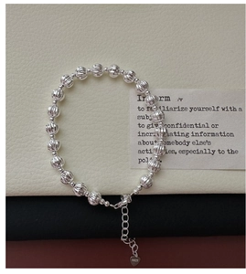Gros plan d'un bracelet à billes en argent S925 avec breloque cœur et détails gravés