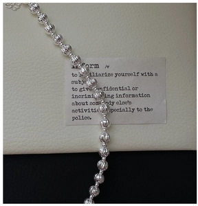 Détail macro du bracelet à perles en argent S925 avec textures facettées et chaîne