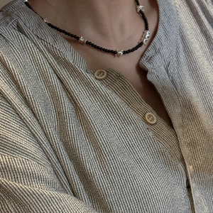 Collier en argent S925 avec agate noire et pièces métalliques irrégulières sur chemise rayée