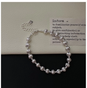 Gros plan d'un bracelet à billes en argent S925 avec fermoir mousqueton et pendentif cœur