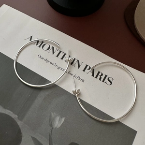 Boucles d'oreilles créoles minimalistes en argent 925 sur une page de magazine chic