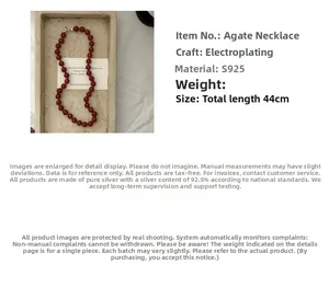 Detailed view of S925 silver necklace featuring red agate beads and knotted design element