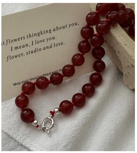 Detail view of deep red agate beaded necklace with handcrafted knots and silver clasp