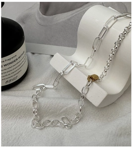 Detail of S925 sterling silver necklace with gold buckle and bicolor mixed chain design