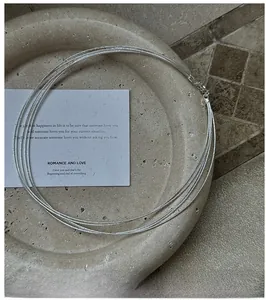Detailed view of multilayer silver choker necklace featuring a textured glitter finish