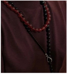 Detail of S925 silver layered necklace with red agate beads and infinity symbol pendant