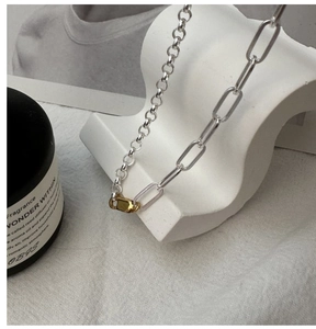 Detail of S925 silver two-tone necklace with gold clasp and mixed chain textures