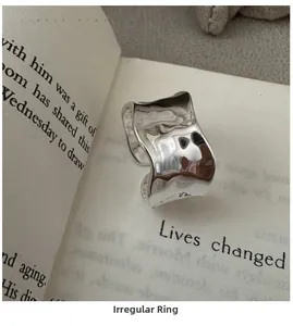 Macro shot of silver S925 sterling silver ring with irregular wavy texture on book